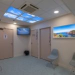 Plafond lumineux et fenêtre virtuelle Cumulux dans une salle d'attente, privée de lumière naturelle chez la clinique de la muette.