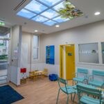 Faux plafond LED ciel Cumulux pour éclairer une salle d'attente sombre pour enfants.