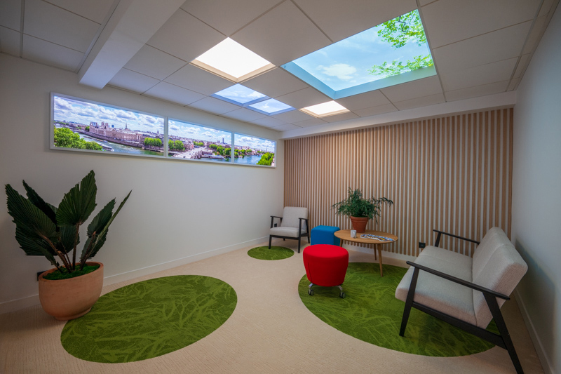 Plafond lumineux ciel et fenêtre virtuelle panoramique dans un salon d'attente.