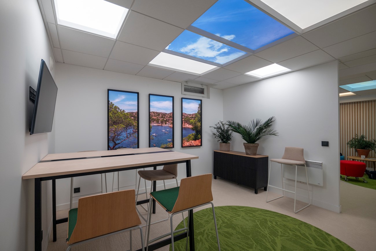 Dalles LED effet ciel et triptyque de fenêtres lumineuses dans un espace de bureau.