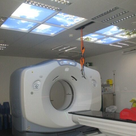 Faux plafonds lumineux ciel Cumulux pour un salle de scanner sombre dans un centre chirurgical.